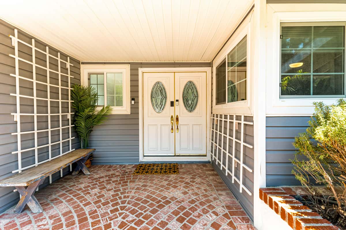 An entryway set up with an outdoor scraper mat, indoor mat and boot tray